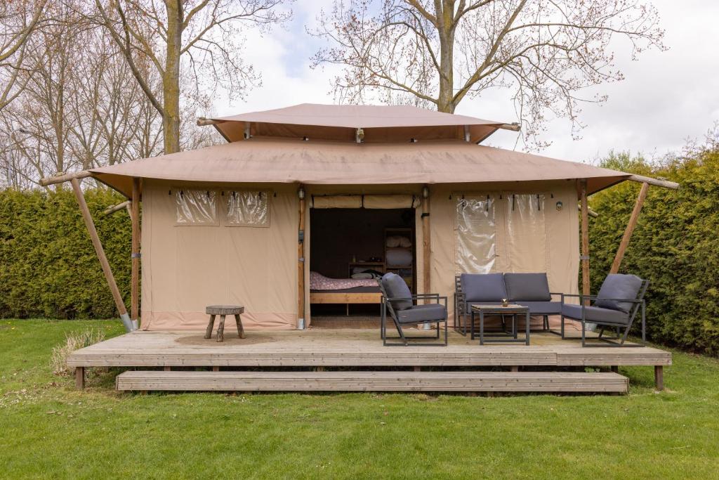 a gazebo with two chairs and a table at Safari Lodge at Back to Basic in Zwaanshoek
