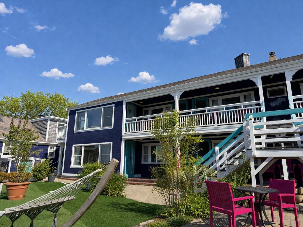 a blue house with purple chairs and a table at The Foxberry - A Digital Concierge Guesthouse in Provincetown