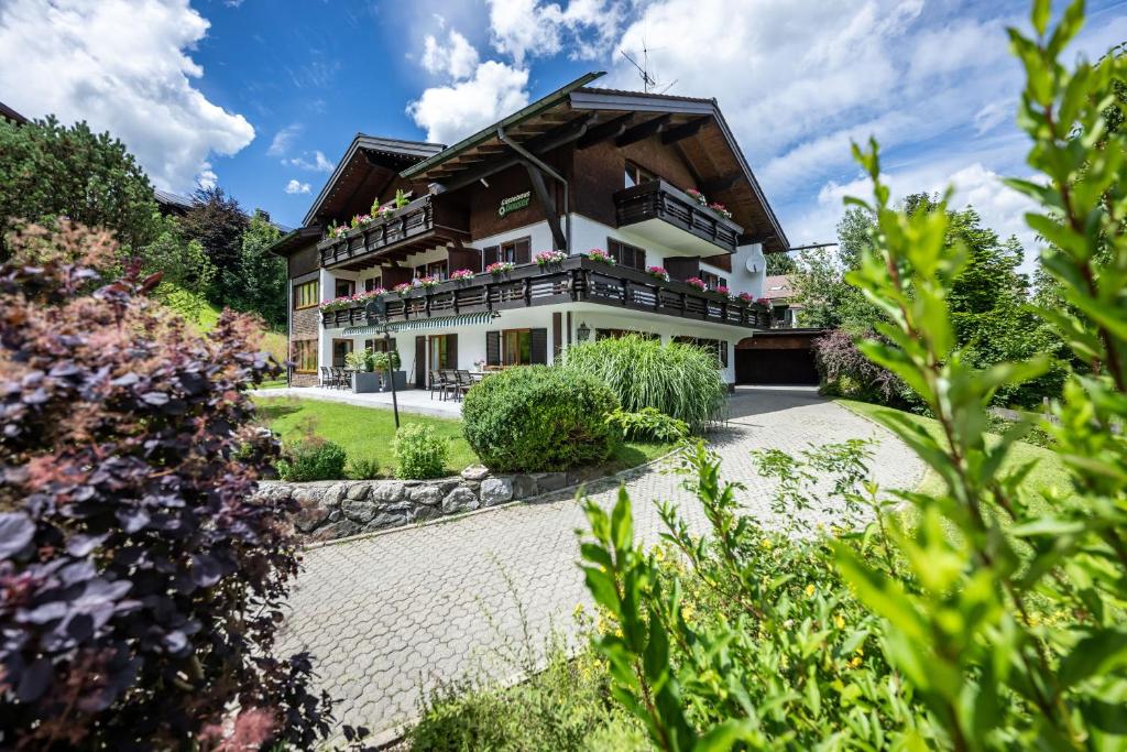 an exterior view of a house with a garden at Gästehaus Dauser in Obermaiselstein