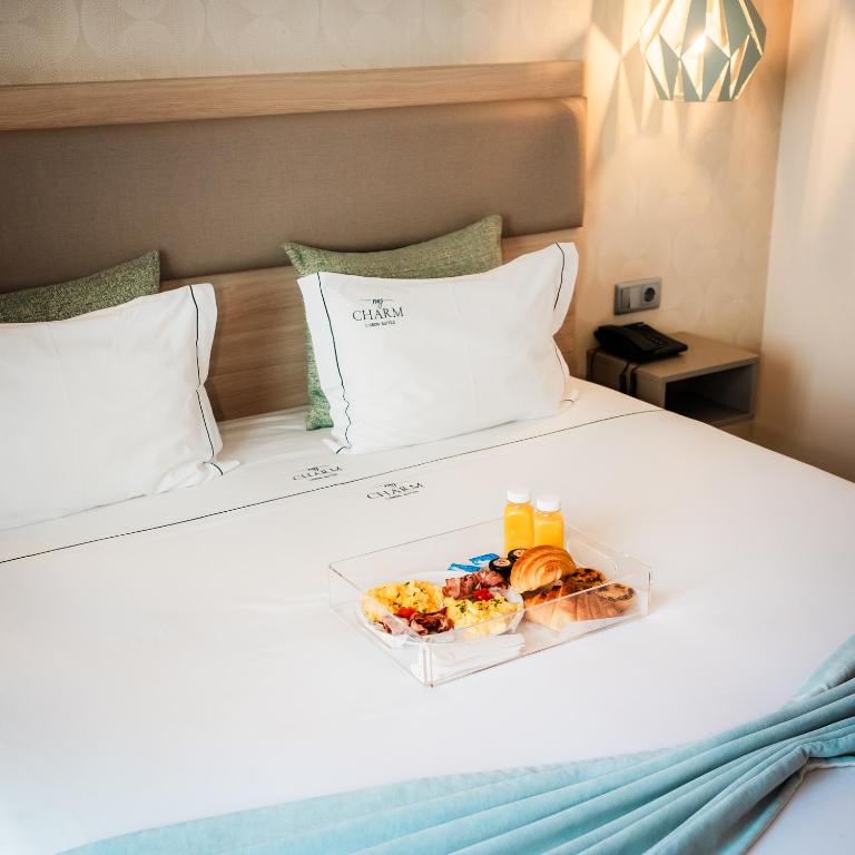 a tray of food sitting on a bed at My Charm Lisbon Suites in Lisbon