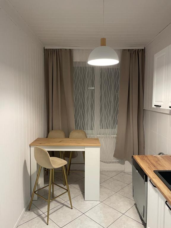 a kitchen with a table and chairs in a room at Jak w domu in Słupsk