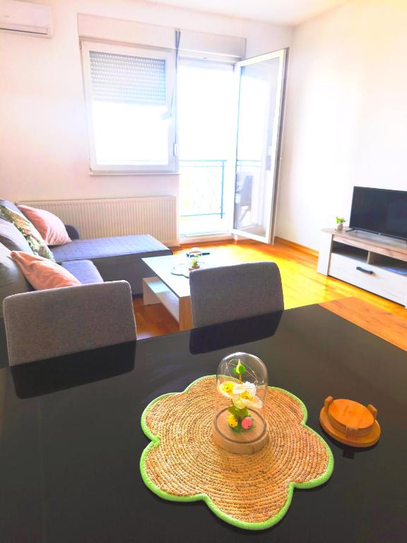a living room with a table with a vase on it at Lux apartman Ub in Ub