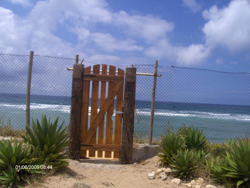a wooden gate in front of a fence on the beach at Finca Malyma with 2 villas and 1 apartment, beach front 10,000m2 botanic garden in Zahora