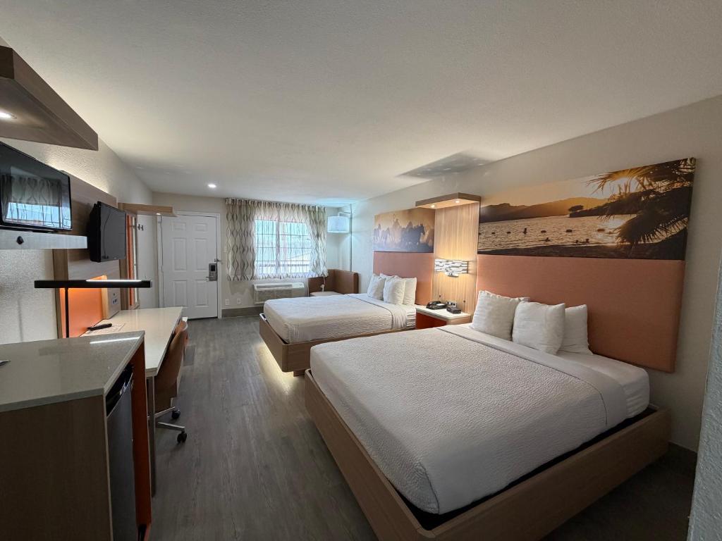 a hotel room with two beds and a kitchen at Days Inn by Wyndham Granbury in Granbury