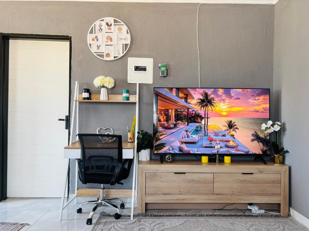 an office with a desk and a television on a wall at The Valley View Nest in Ezulwini