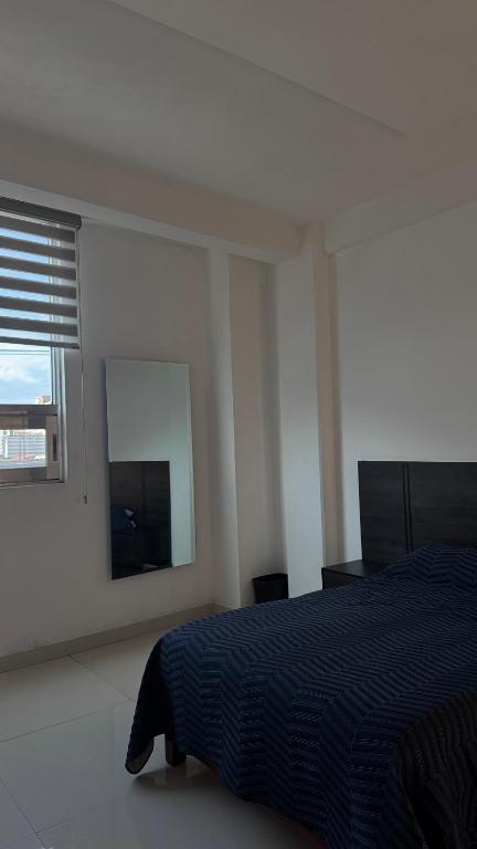 a bedroom with a bed and a mirror and a window at Suite Privada Moderna in Santa Ana Chiautempan