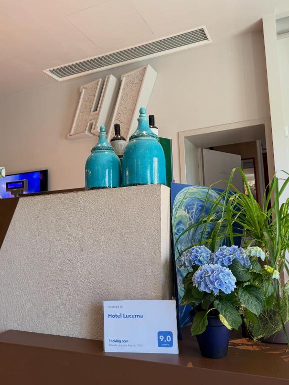 four blue glass vases sitting on top of a counter at Hotel Lucerna in Castiglione della Pescaia