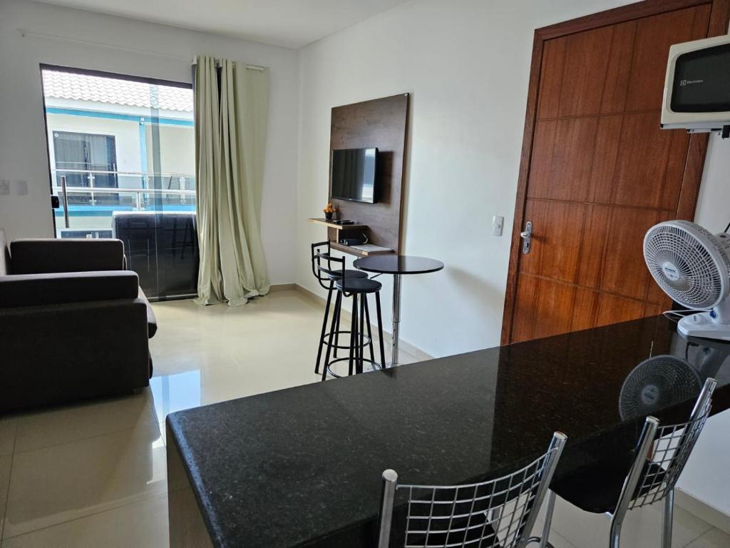 a kitchen and living room with a table and chairs at Apto Garden Taperapuan 2 quartos com suíte in Porto Seguro