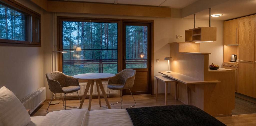 a room with a bed and a table and chairs at Tiera Resort in Taivalkoski