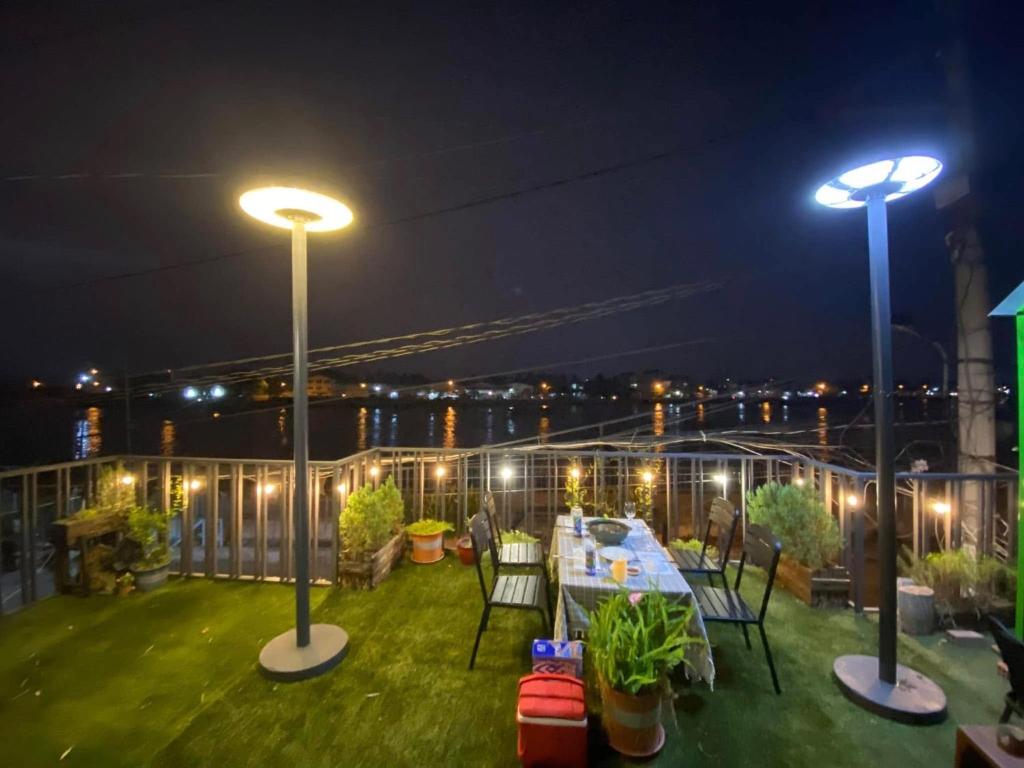 a rooftop patio with a table and lights at night at Kỳ Duyên House in Cái Răng
