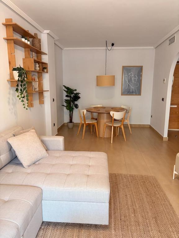 a living room with a white couch and a table at Casa Sol Serena - Pool, Beach & Golf in Los Alcázares