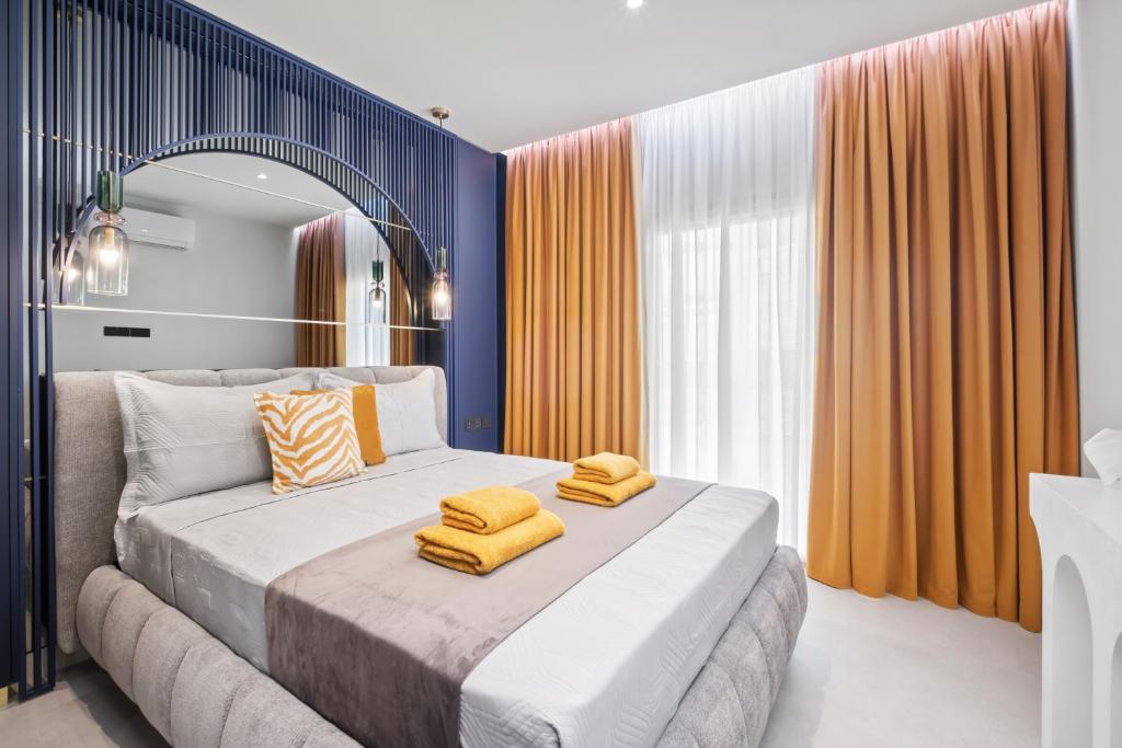 a bedroom with a bed with yellow towels on it at FatCow Suites City Centre in Larnaca