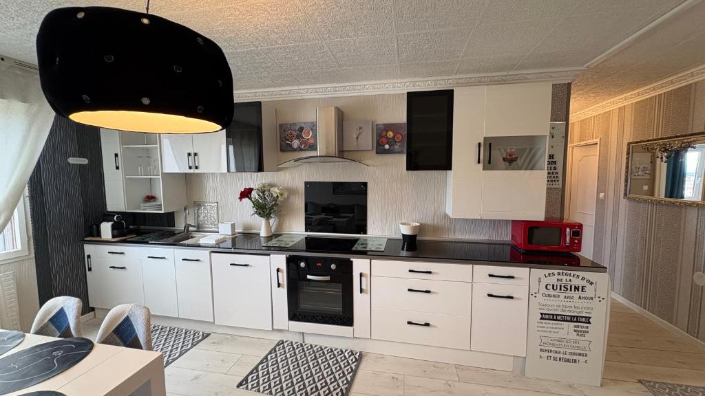a kitchen with white cabinets and a black appliance at Bellevue in Colmar