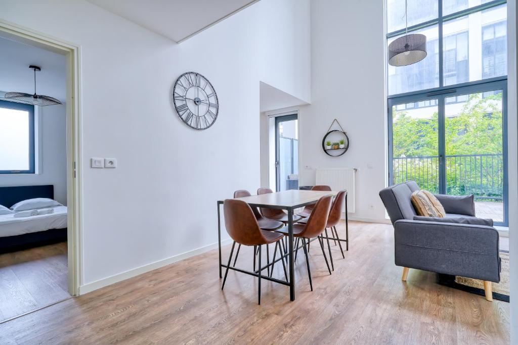 a dining room and living room with a table and chairs at Gorgeous duplex near top attractions in Saint-Ouen
