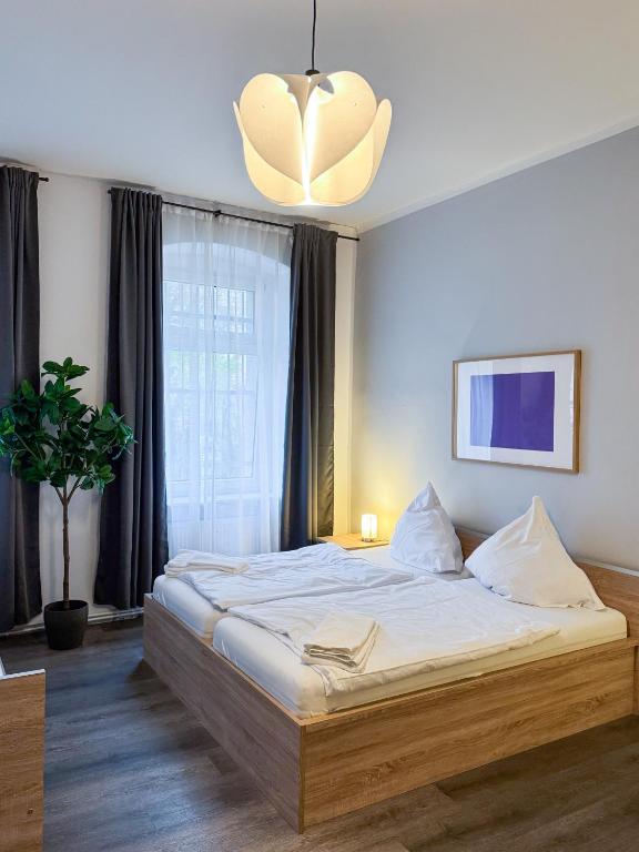 a bedroom with a bed and a large window at City-Apartment Schöneweide in Berlin