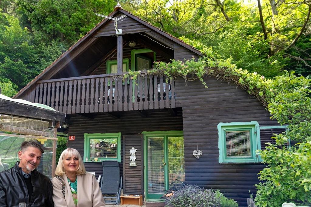 a man and woman standing in front of a house at Počitniška hiša Eva in Velike Lašče