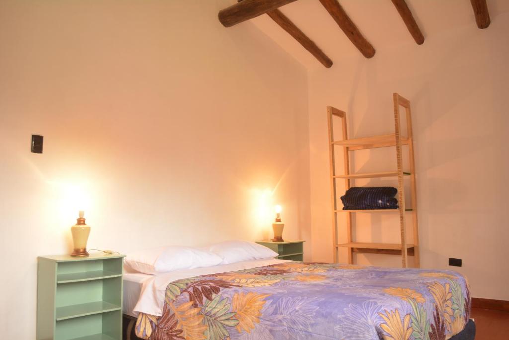 a bedroom with a bed with two night stands and a shelf at Raíz Azul in Pisac