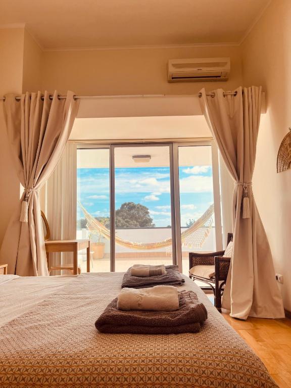 a bedroom with a bed with a view of the ocean at Ilhéu à Vista in Água de Alto