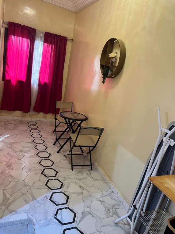 a room with two chairs and a mirror and pink curtains at Residence Meuble Zac Mbao in Kammba