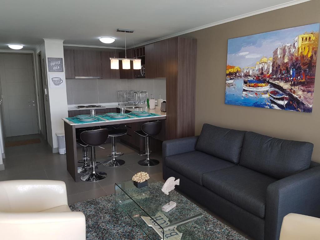 sala de estar con sofá y cocina en Laguna del Mar Apartamento 208, en La Serena