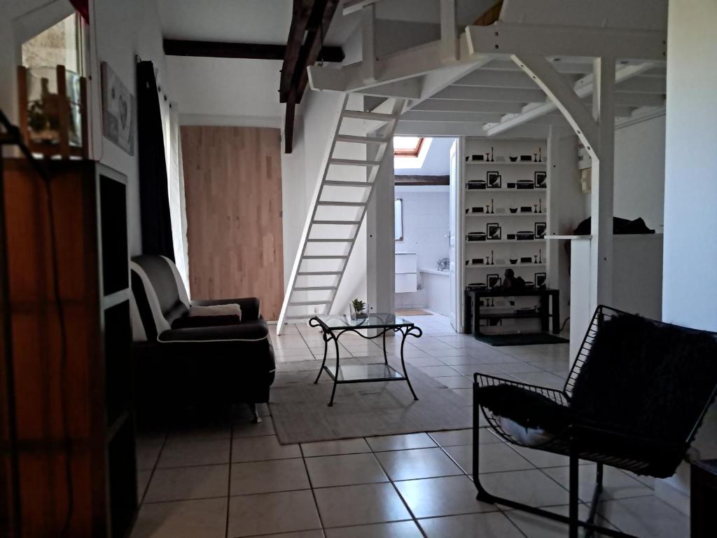 a living room with two chairs and a staircase at Appart cosy Disney paris in Chalifert