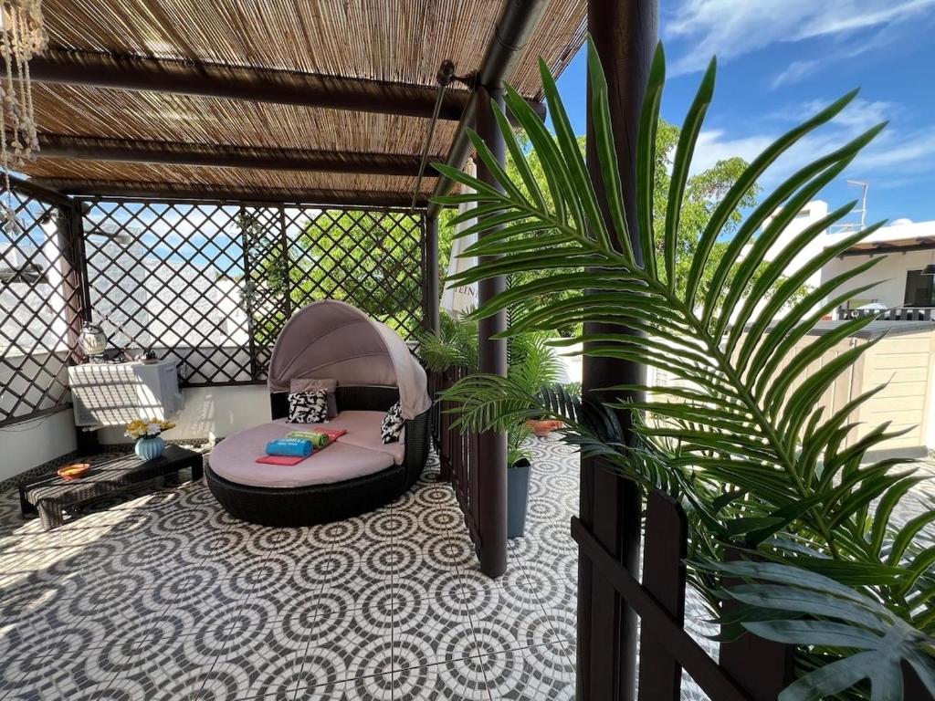 a gazebo with a bed and a plant on a patio at Swallows Nest in Quarteira