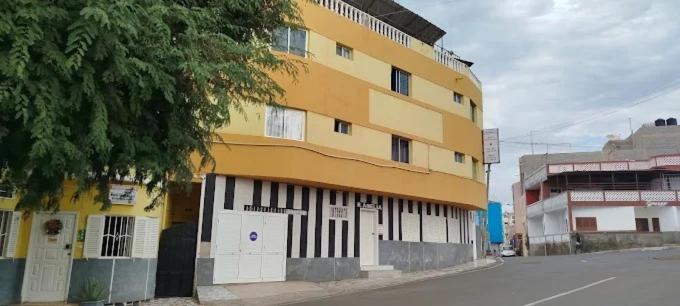 a yellow and white building on the side of a street at Residencial Monte Sintinha in Espargos
