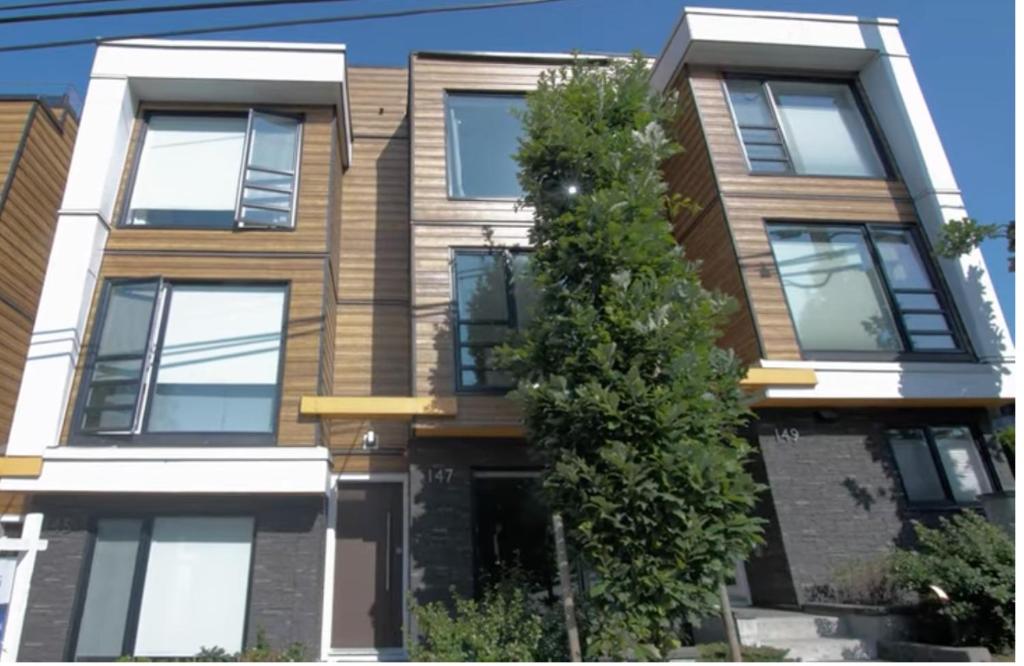 an apartment building with a tree in front of it at Elite Townhouse at the Shipyaards in North Vancouver