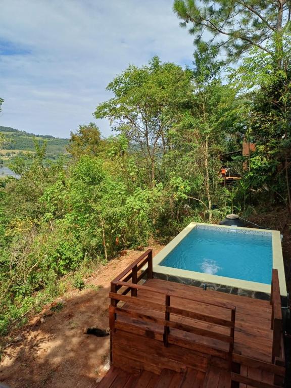 a swimming pool with a wooden bench next to at Bambú Cabaña in El Soberbio