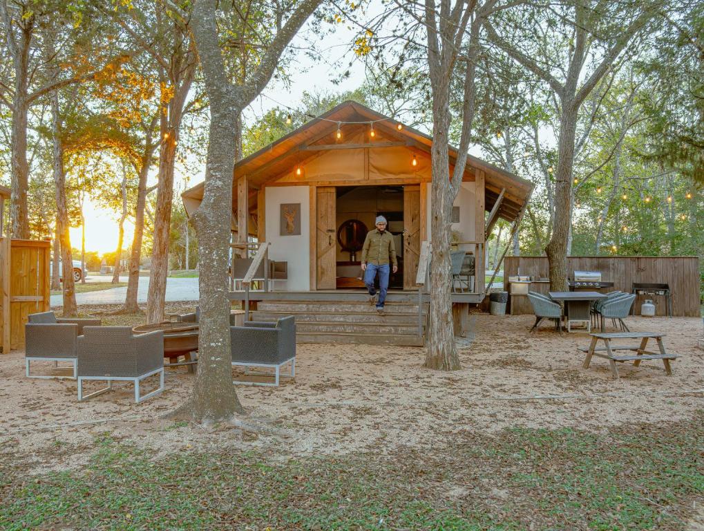 a man walking into a tiny house in the woods at Premium Lakefront Cabin 1 The Armadillo in Bastrop