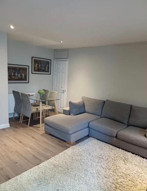 a living room with a couch and a table at The Mews Holywell in Holywell