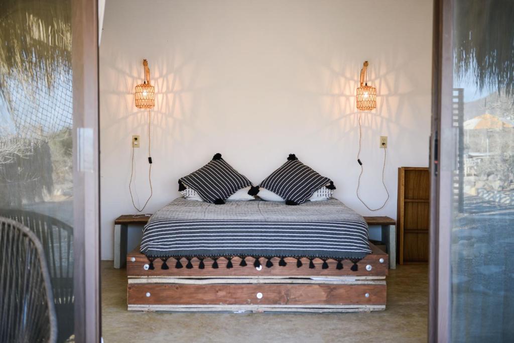 a bedroom with a bed with two pillows on it at Ohana cerritos in El Pescadero