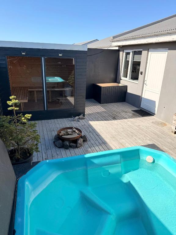 a swimming pool in front of a house at Studio with Private Spa Garden in Njarðvík