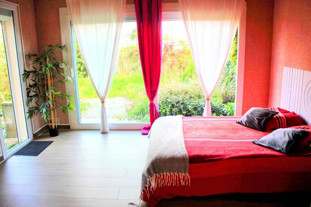 ein Schlafzimmer mit einem Bett und einem großen Fenster in der Unterkunft Chambres Spacieuses et Lumineuses - Angers - Votre havre de paix in Angers