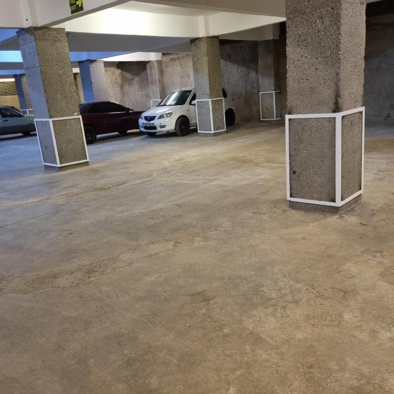 an empty parking lot with a car parked in a parking garage at Royalty homes in Kiambu