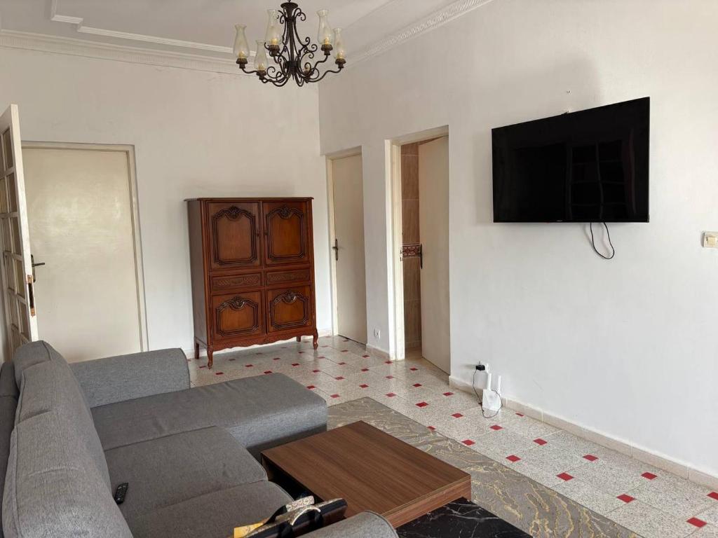 a living room with a couch and a tv on a wall at Villa Meryem in Tangier