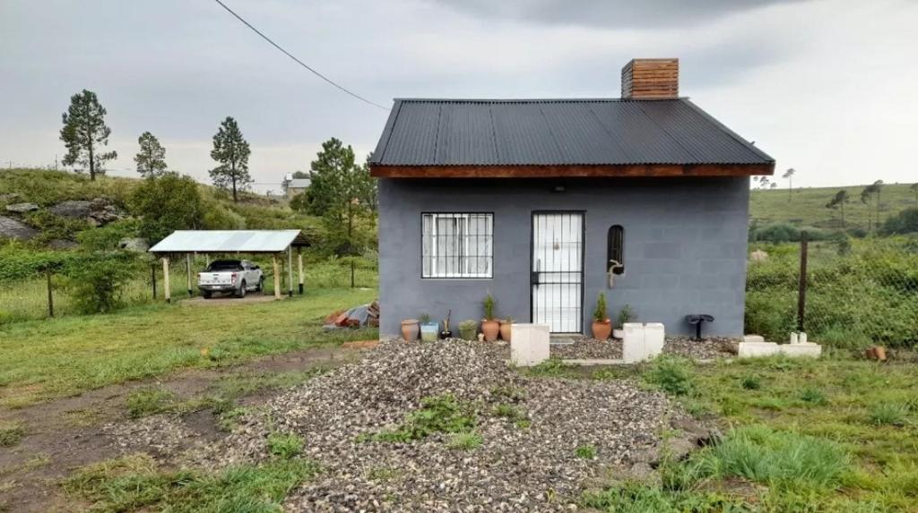 a small house in the middle of a field at Vertiente escondida in Villa Yacanto