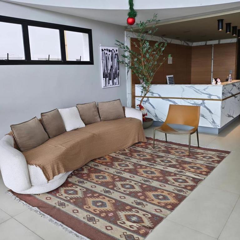 a living room with a couch and a rug at Flats Beira Mar in Caraguatatuba