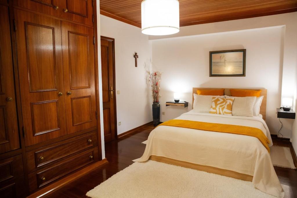 a bedroom with a large bed and a brown cabinet at Casa da Lala - Alojamento a 4km de Fátima in Fontainhas