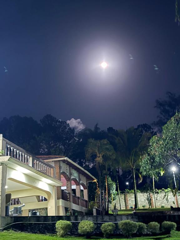 a building at night with the moon in the sky at Complejo de villas regazo de paz in Buena Vista
