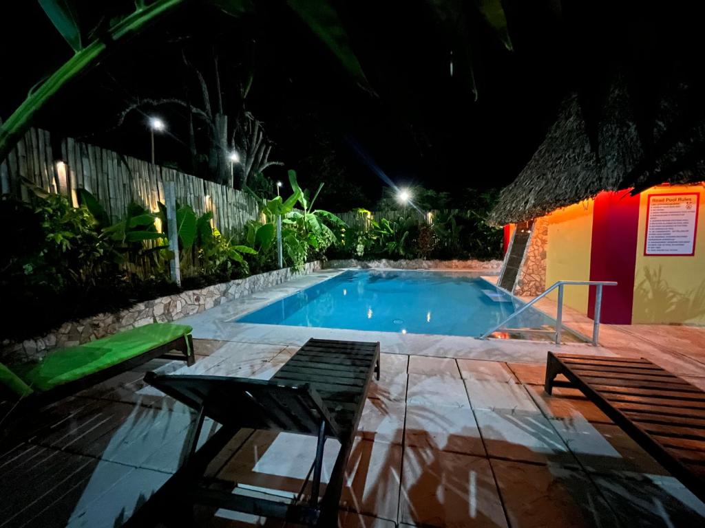 a swimming pool at night in a resort at Lamanai Hotel & Marina in Orange Walk