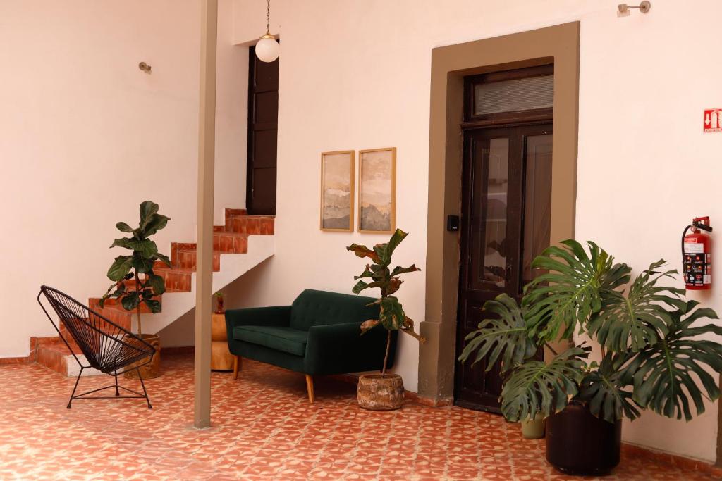 a living room with a green chair and potted plants at Casa Sabina Expiatorio in Guadalajara