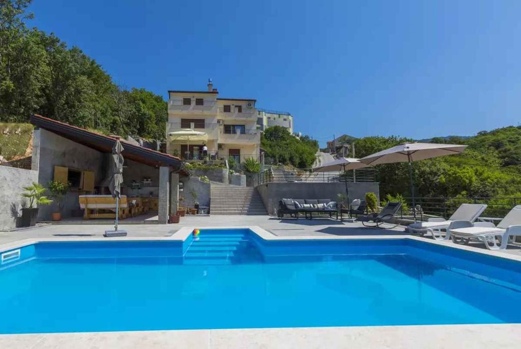a swimming pool in front of a house at Apartment in Hreljin 39448 in Hreljin