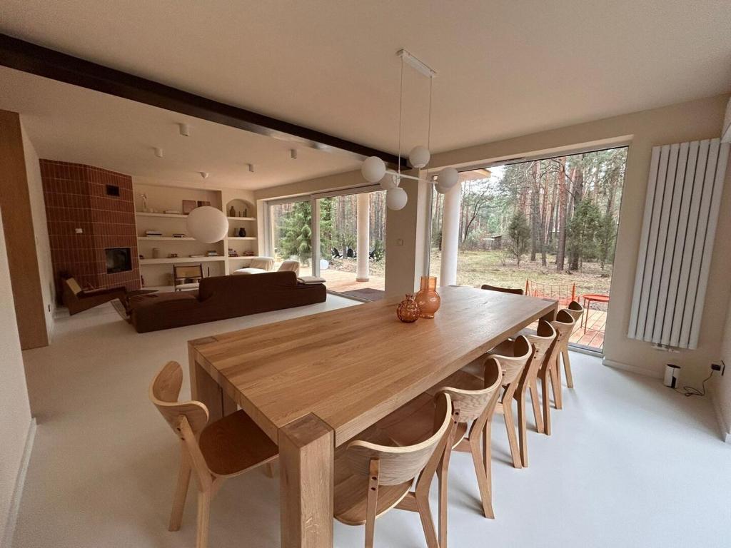a dining room with a large wooden table and chairs at Forest Hub Popowo in Huta Podgórna