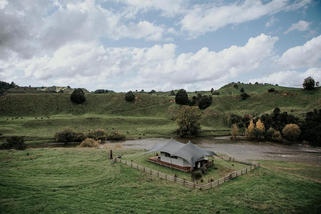a tent in the middle of a field at Te Awa Glamping in Taumarunui