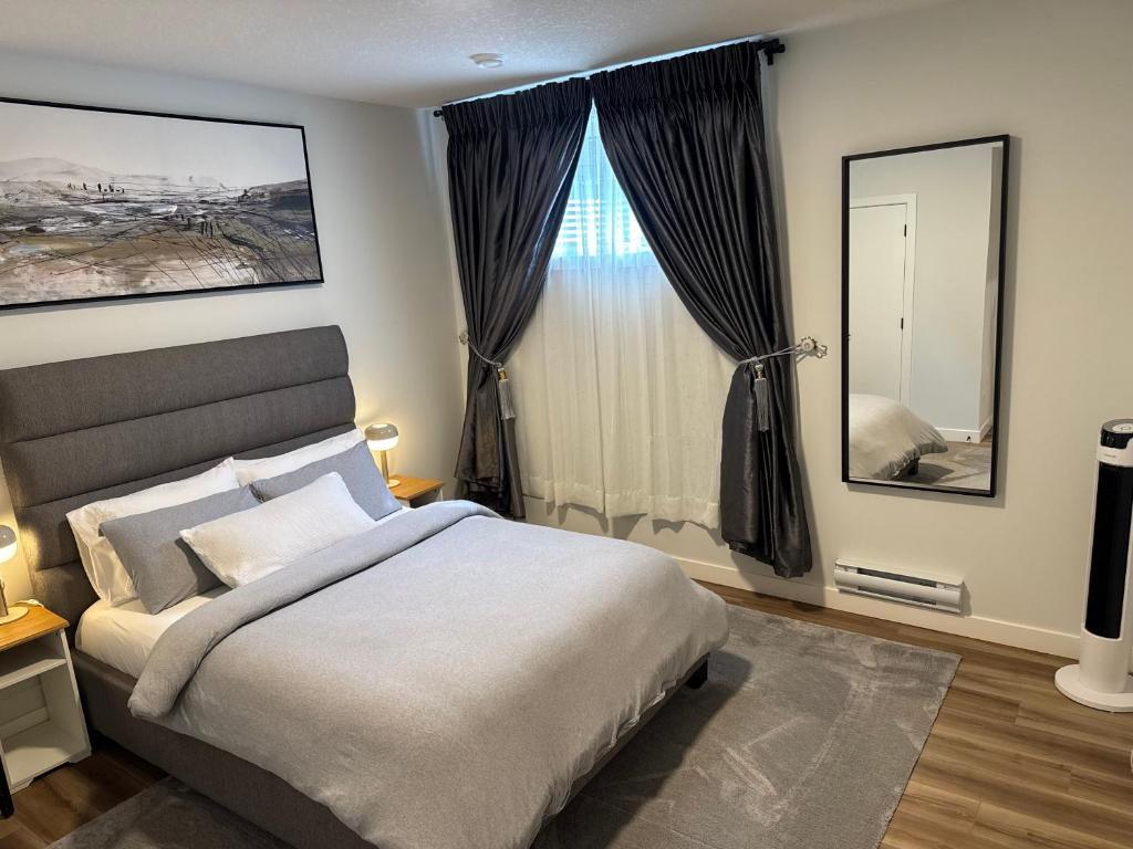 a bedroom with a bed and a large window at 5 Star Suite with Free Parking and Easy Access to Downtown in Calgary