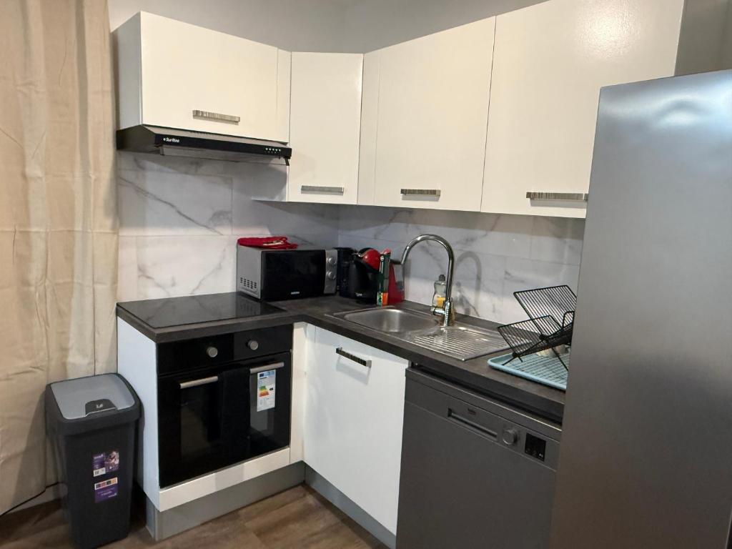 a small kitchen with a sink and a microwave at Cosy home in Saint Martin