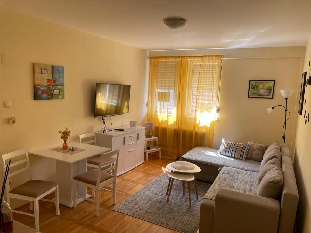 a living room with a couch and a table at SkyBreak Apartment in Ledine