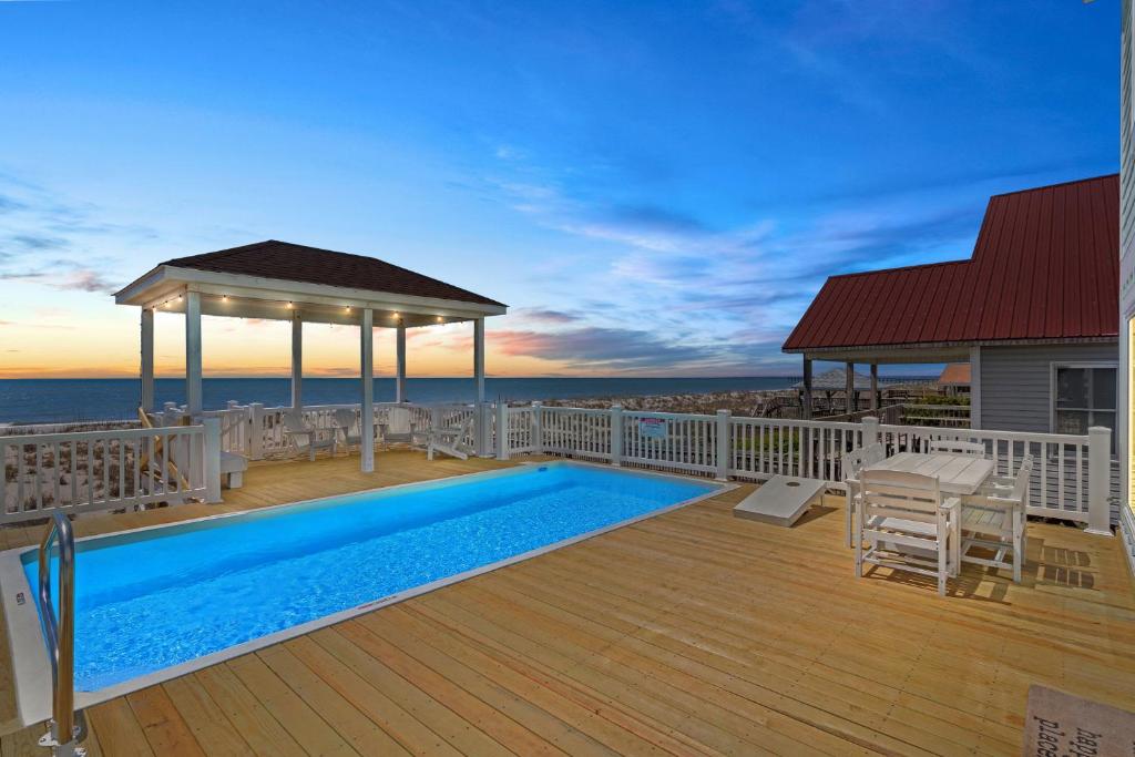 a deck with a swimming pool and a gazebo at Oceanfront Luxury Private Steps to Beach New in Oak Island