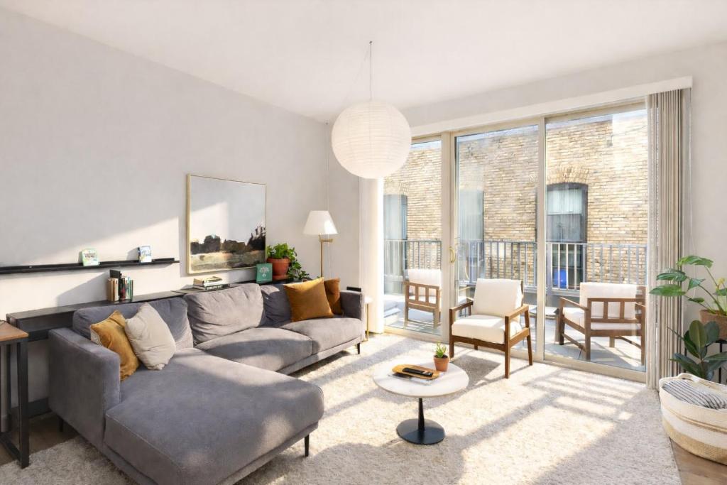 a living room with a couch and a table at Charming Walker's Point Apt with Balcony | Sleeps 4 in Milwaukee